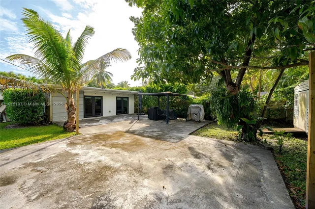 a view of a patio with a table and chairs and potted plants
