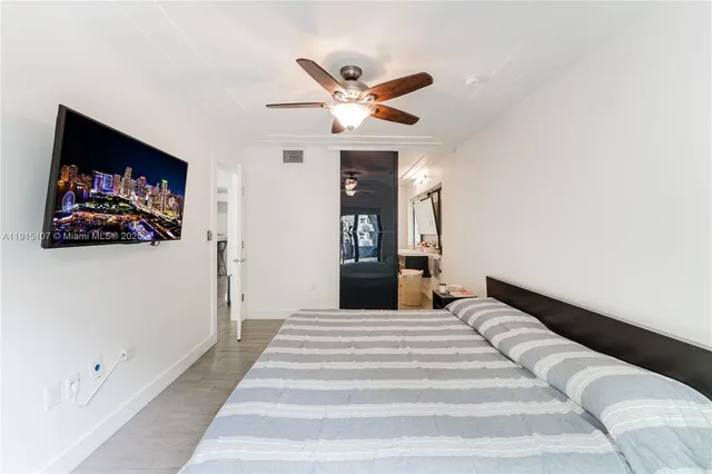 a bedroom with a bed and a ceiling fan