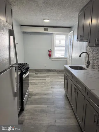 a kitchen with stainless steel appliances a sink stove and cabinets