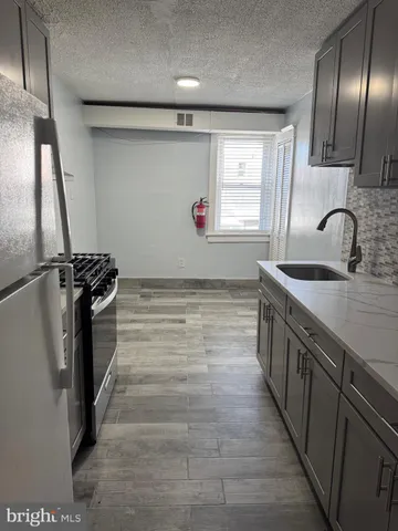a kitchen with stainless steel appliances a sink stove and cabinets