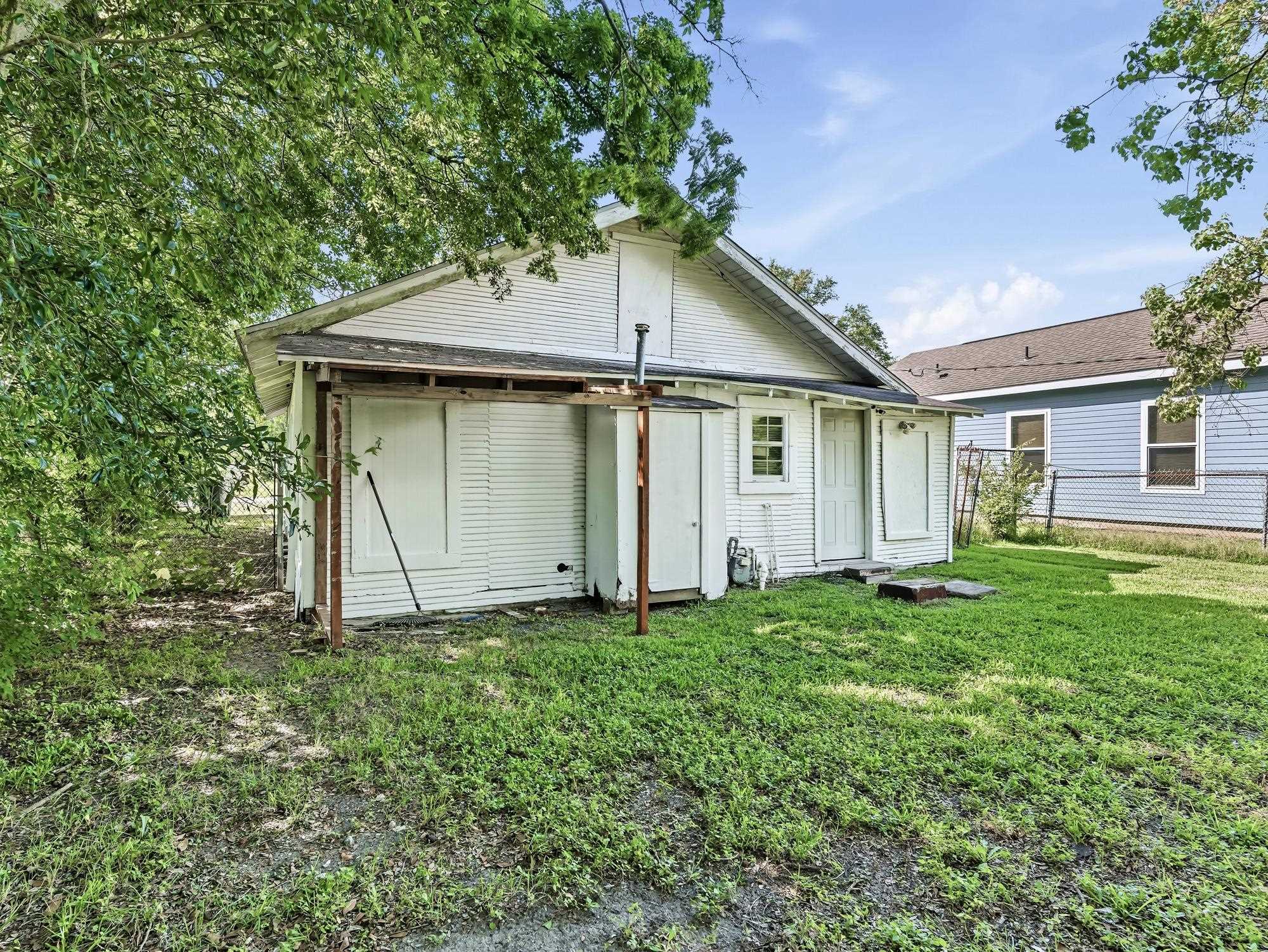 737 9th Street Port Arthur, TX 77640 - Photo 19 of 20 a white house that has a small yard and large trees