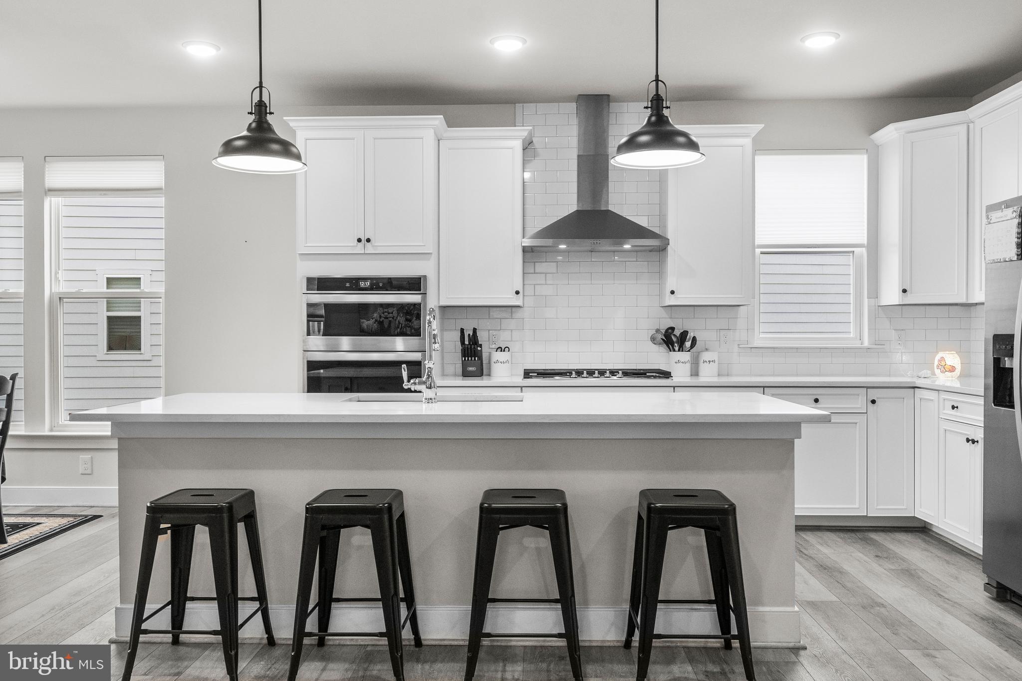 1814 River Heritage Boulevard Dumfries, VA 22026 - Photo 2 of 55 a kitchen with stainless steel appliances granite countertop a dining table chairs sink and white cabinets