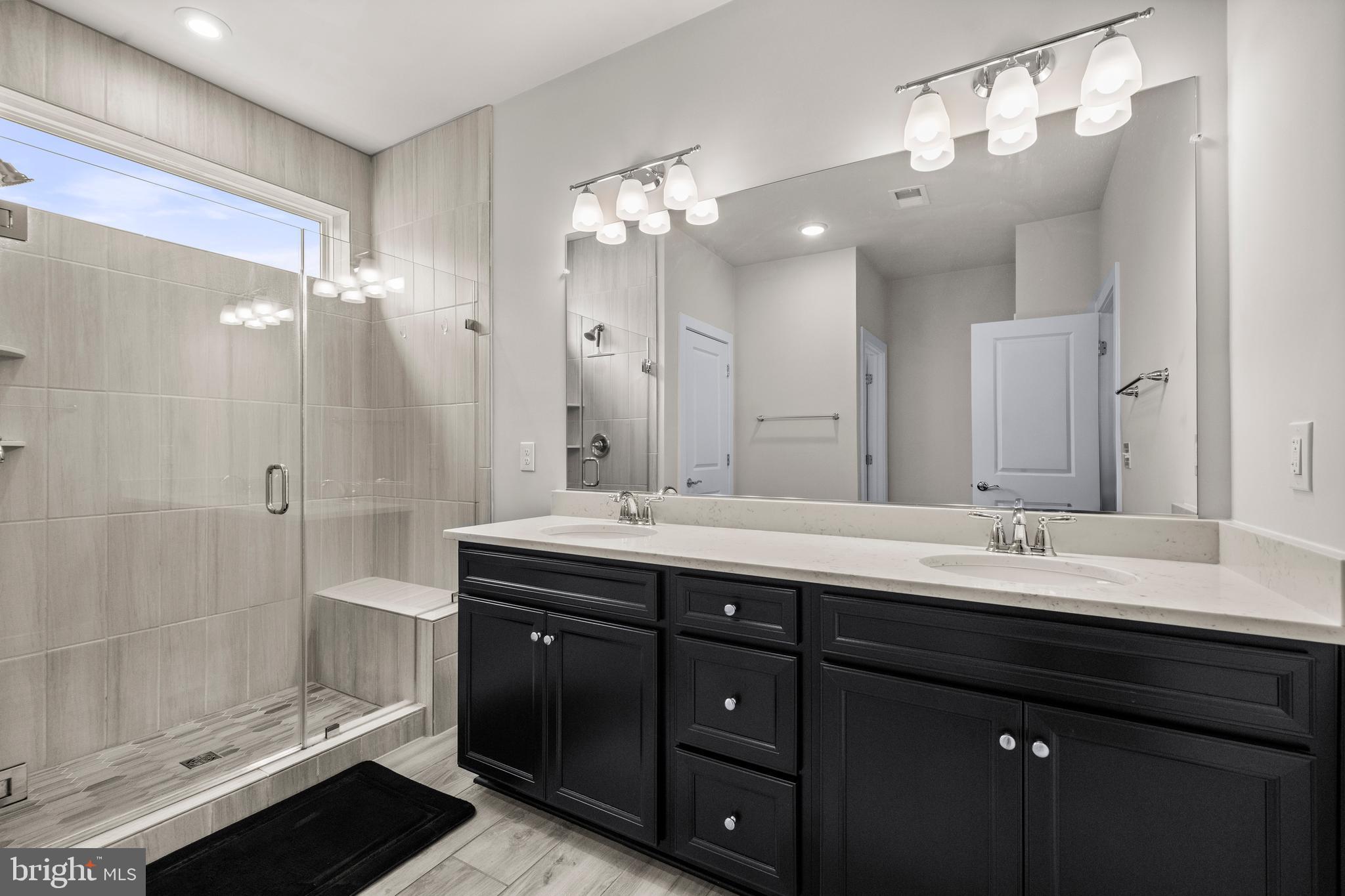 1814 River Heritage Boulevard Dumfries, VA 22026 - Photo 22 of 55 a bathroom with a double vanity sink mirror and shower