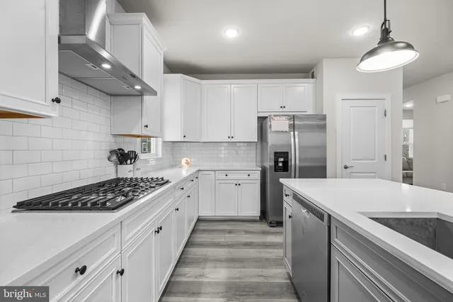a kitchen with white cabinets and black appliances
