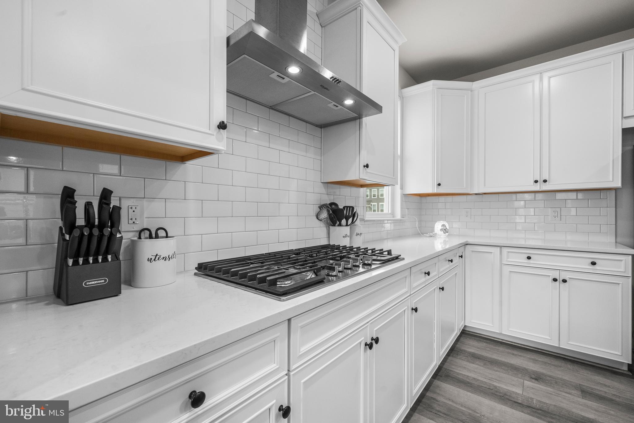 1814 River Heritage Boulevard Dumfries, VA 22026 - Photo 6 of 55 a kitchen with white cabinets and black appliances