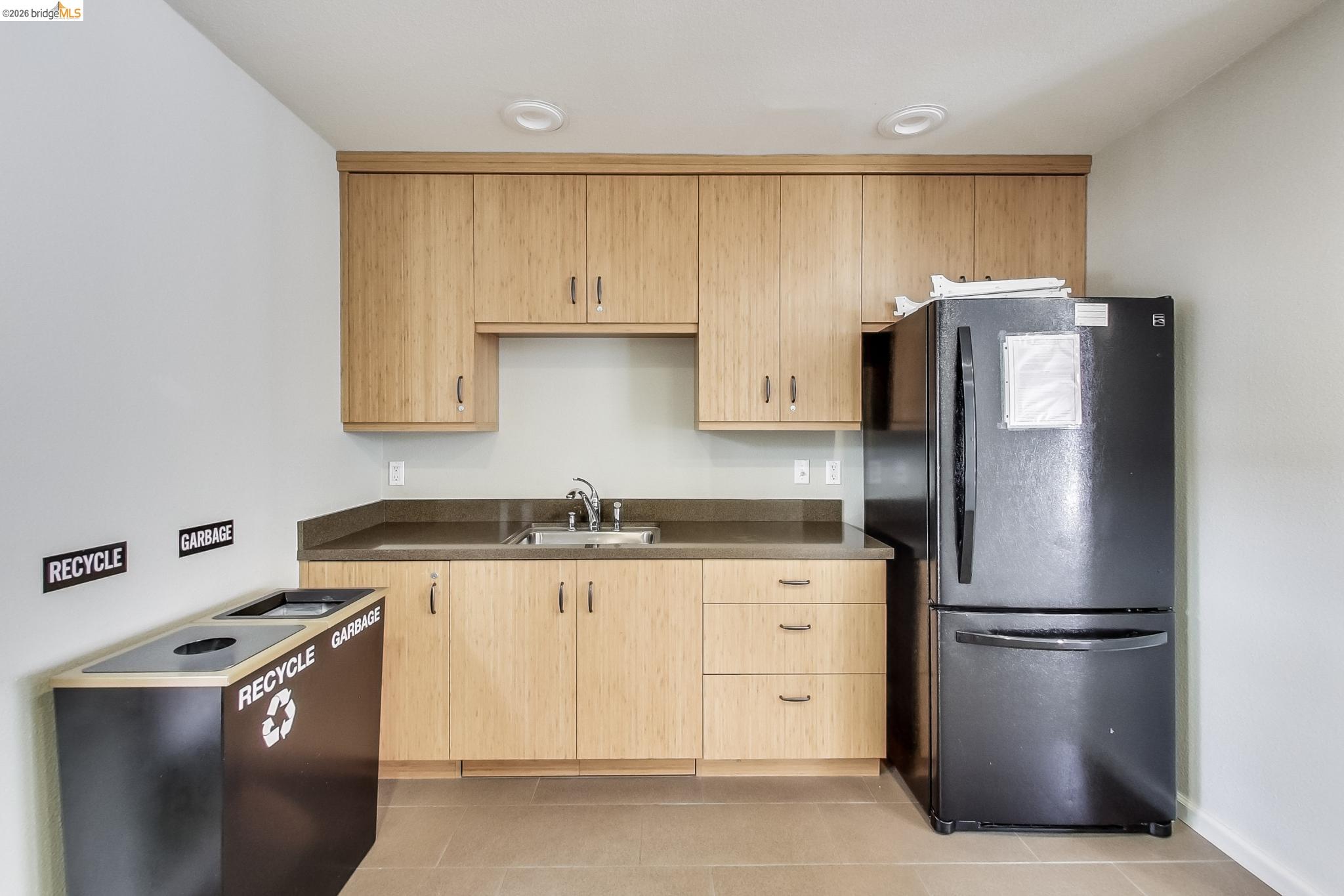 555 10th Street, Unit 312 Oakland, CA 94607 - Photo 28 of 34 a kitchen with stainless steel appliances granite countertop a refrigerator a sink and white cabinets