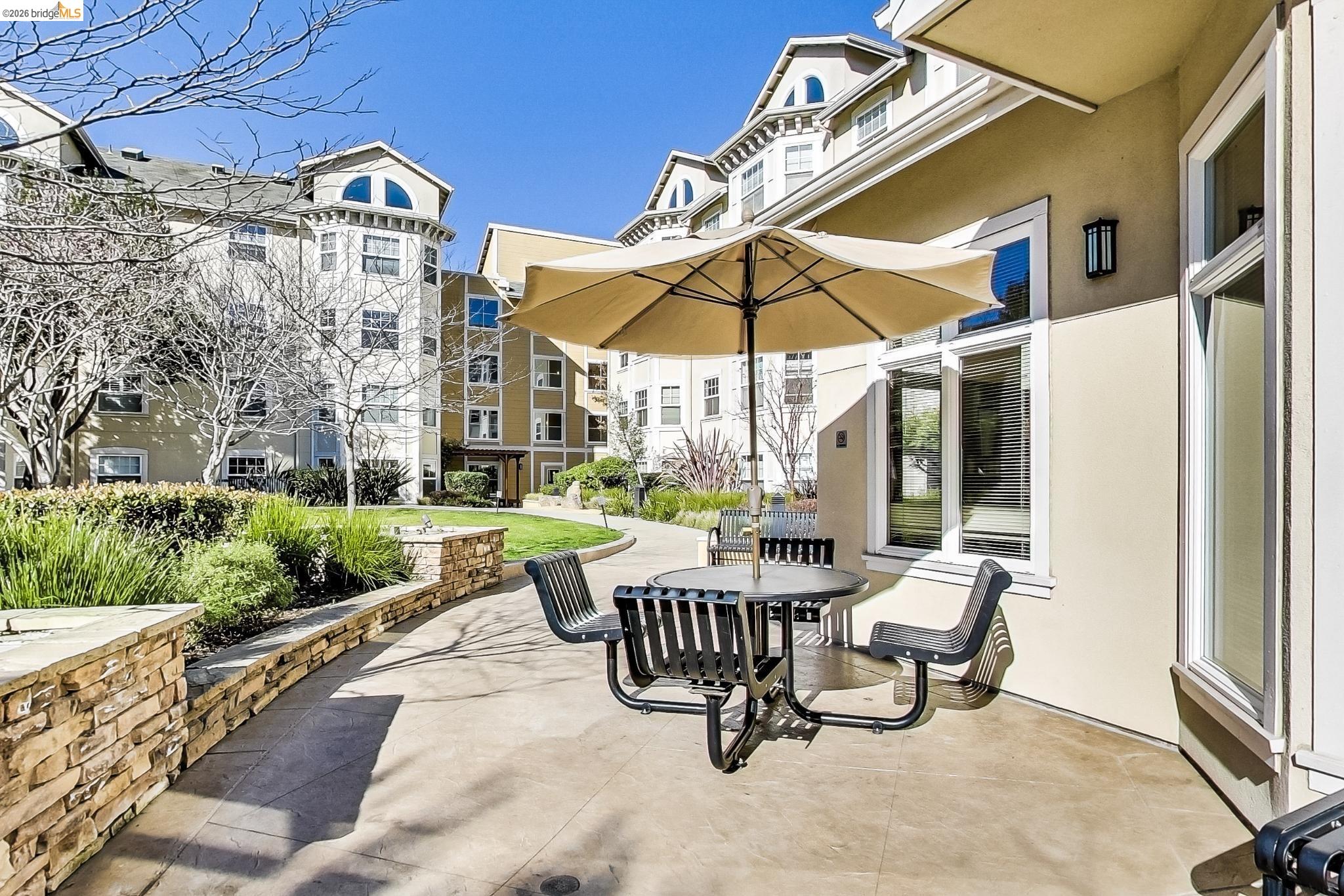 555 10th Street, Unit 312 Oakland, CA 94607 - Photo 31 of 34 a view of a patio with a table and chairs under an umbrella