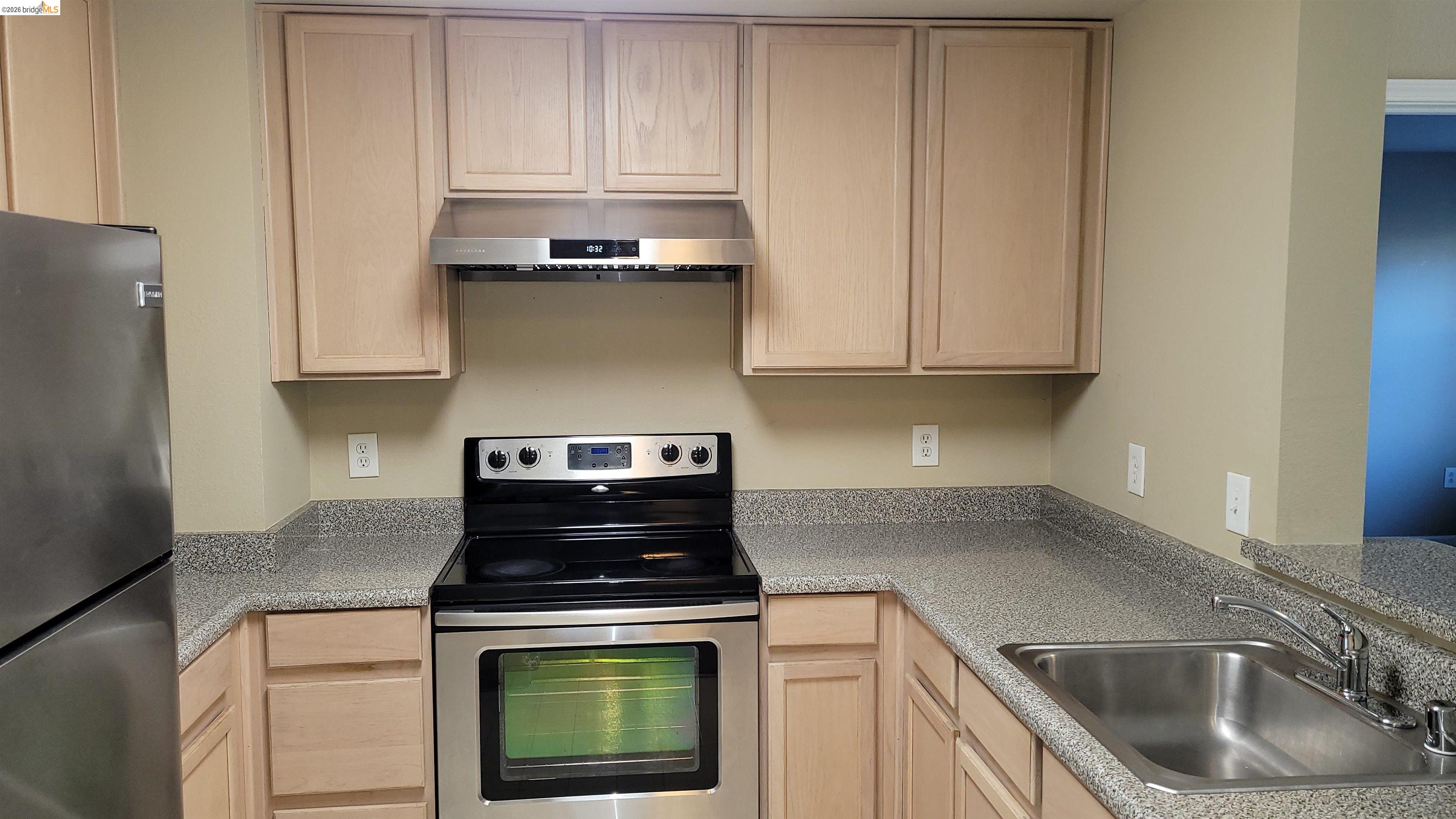 555 10th Street, Unit 312 Oakland, CA 94607 - Photo 7 of 34 a kitchen with granite countertop white cabinets and stainless steel appliances
