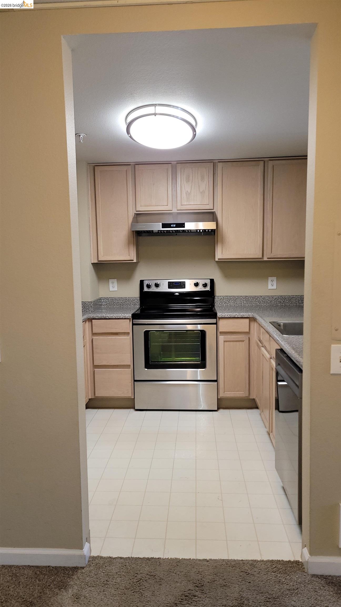 555 10th Street, Unit 312 Oakland, CA 94607 - Photo 8 of 34 a kitchen with a stove top oven and cabinets