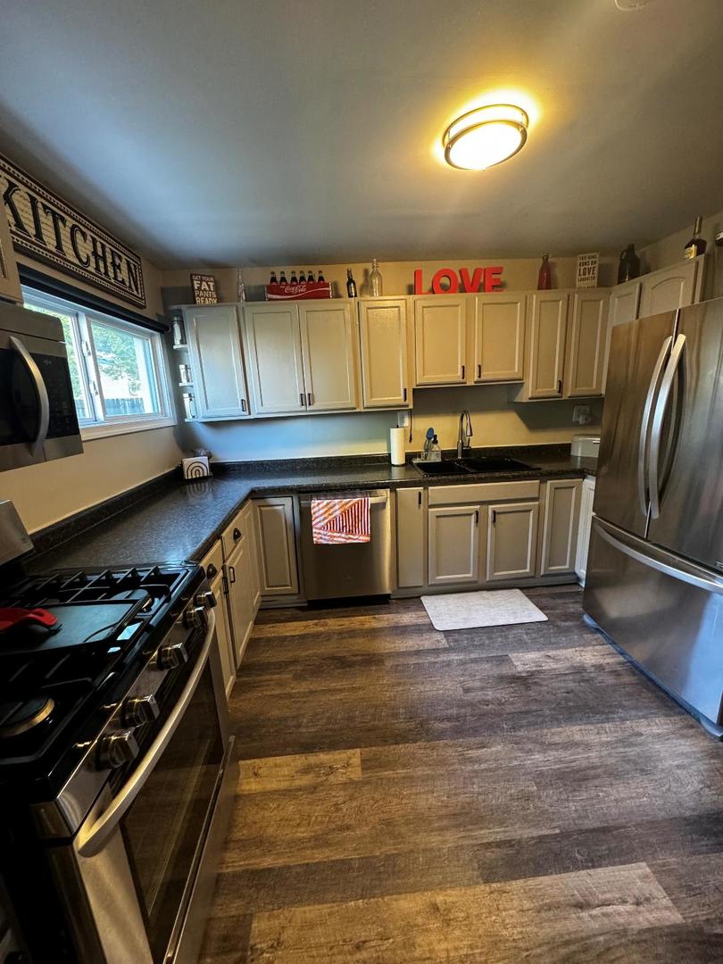 11 Cross Street Bristol, IL 60512 - Photo 2 of 11 a kitchen with stainless steel appliances granite countertop a stove a sink and a microwave