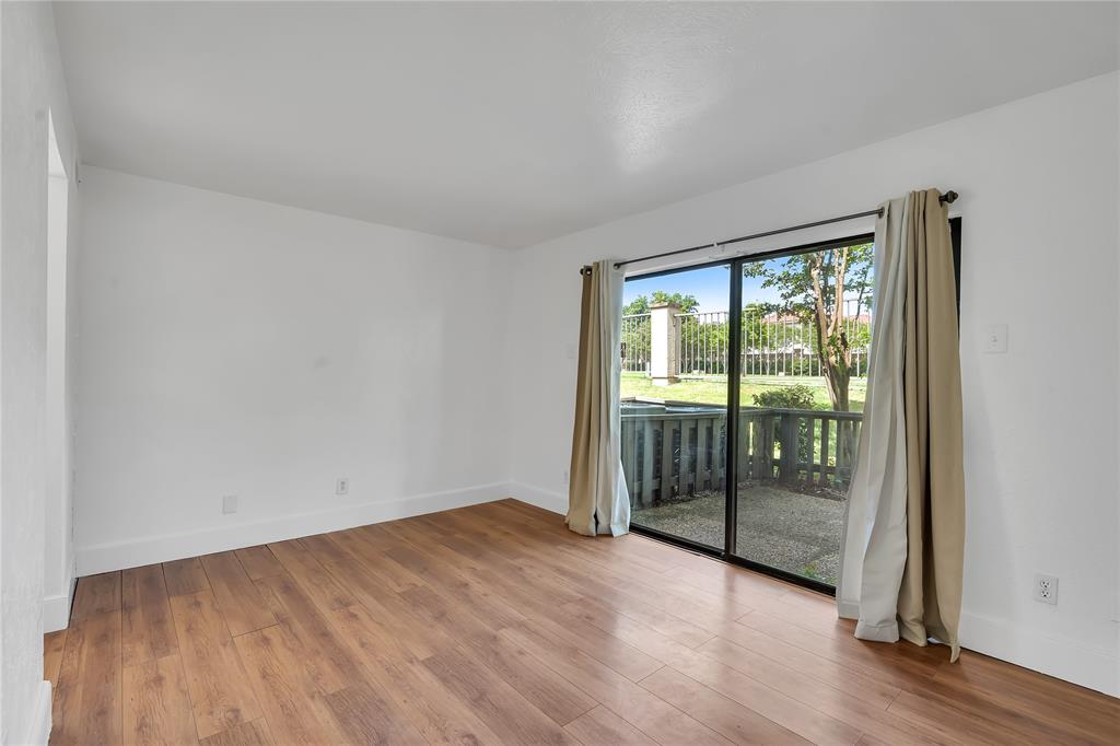 4525 North O'Connor Road, Unit 1184 Irving, TX 75062 - Photo 13 of 20 The room features wood flooring, white walls, and a large sliding glass door