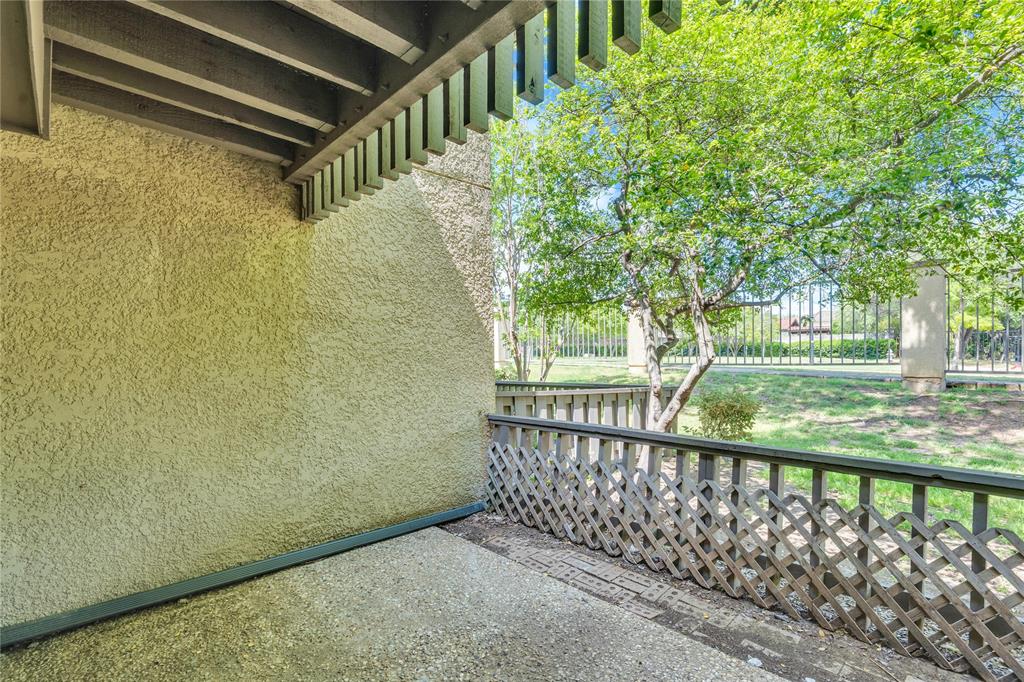 4525 North O'Connor Road, Unit 1184 Irving, TX 75062 - Photo 20 of 20 The property features an outdoor patio area with a lattice-style wooden railing and a textured exterior wall