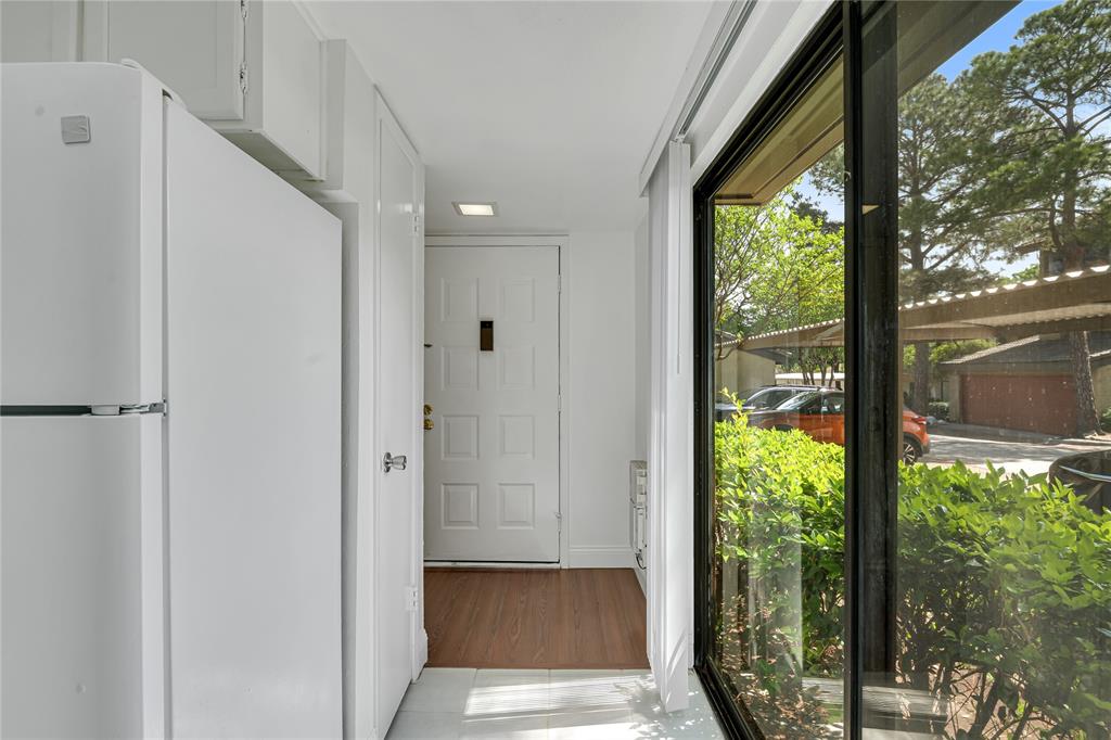 4525 North O'Connor Road, Unit 1184 Irving, TX 75062 - Photo 3 of 20 Entryway featuring hardwood style flooring, a white paneled door, and a full-length window providing views of outdoor landscaping and covered parking