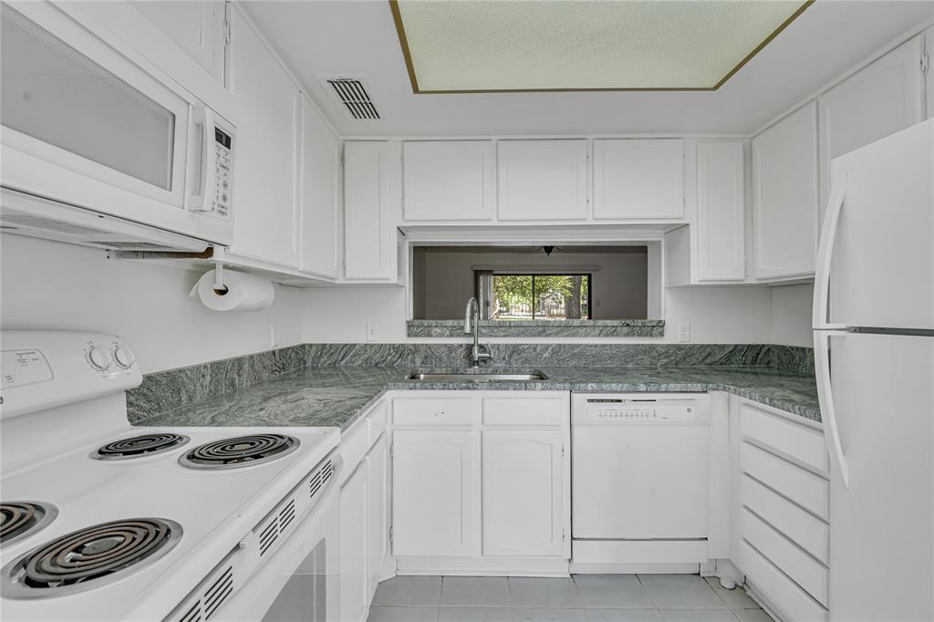 4525 North O'Connor Road, Unit 1184 Irving, TX 75062 - Photo 5 of 20 The kitchen features white cabinetry, a white refrigerator, and a white oven with a microwave above