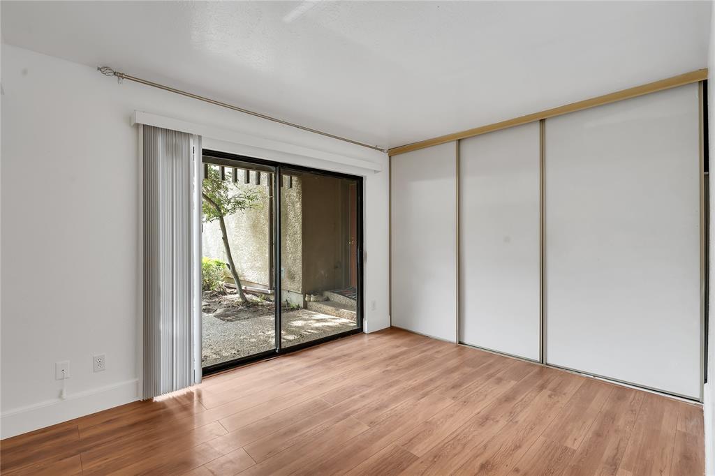 4525 North O'Connor Road, Unit 1184 Irving, TX 75062 - Photo 8 of 20 This room features hardwood flooring, white walls, and a sliding glass door that opens to an exterior space with vegetation