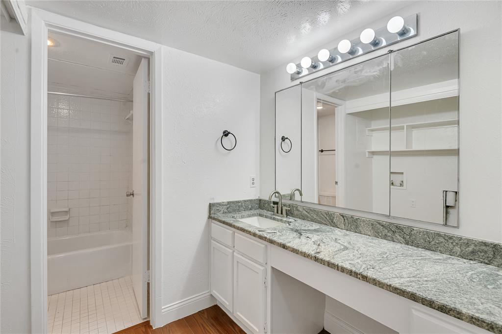 4525 North O'Connor Road, Unit 1184 Irving, TX 75062 - Photo 10 of 20 The bathroom features a long vanity with a stone countertop, an integrated sink, and white cabinetry