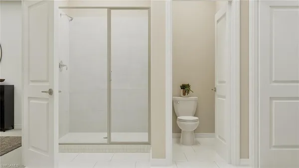 a bathroom with a granite countertop toilet and a shower