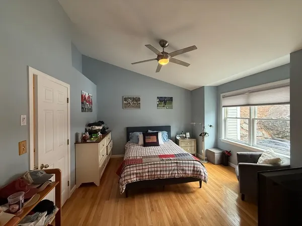a bedroom with a bed and wooden floor