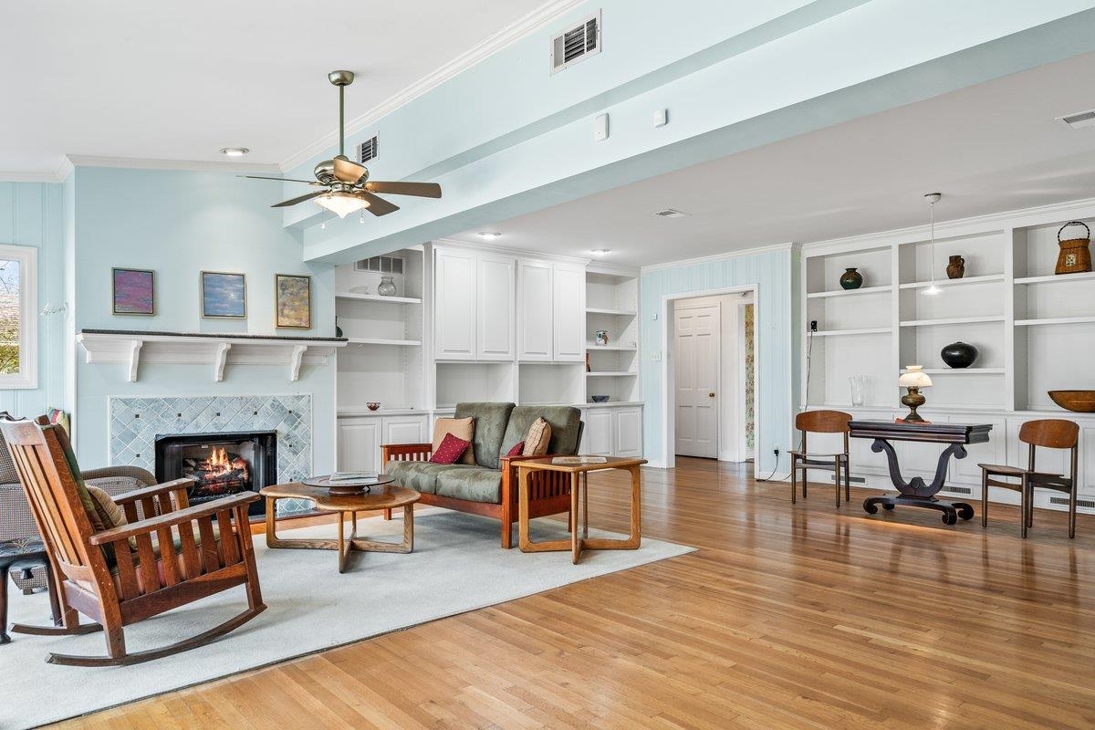 353 Colonial Road Memphis, TN 38117 - Photo 11 of 37 Living area with built in features, crown molding, light wood-style flooring, a tile fireplace, and ceiling fan