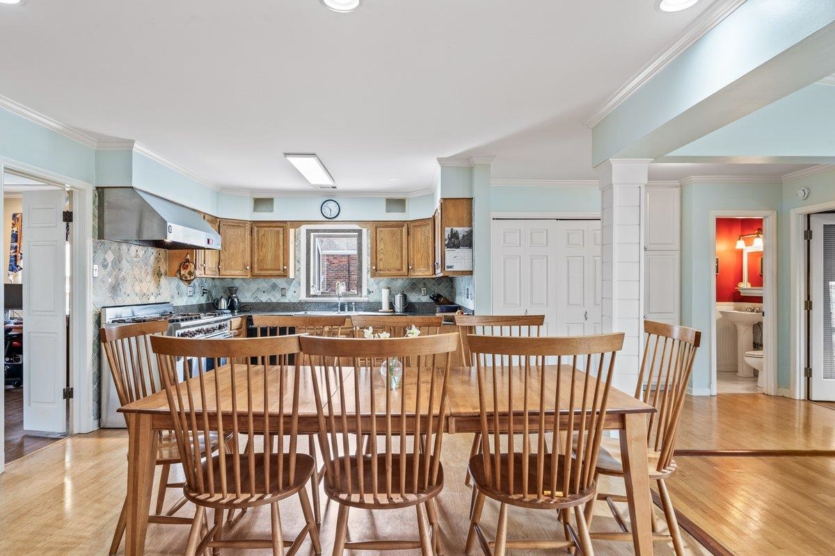 353 Colonial Road Memphis, TN 38117 - Photo 17 of 37 Kitchen with tasteful backsplash, wood finish cabinetry, ornamental molding, light wood finished floors, and gas stove