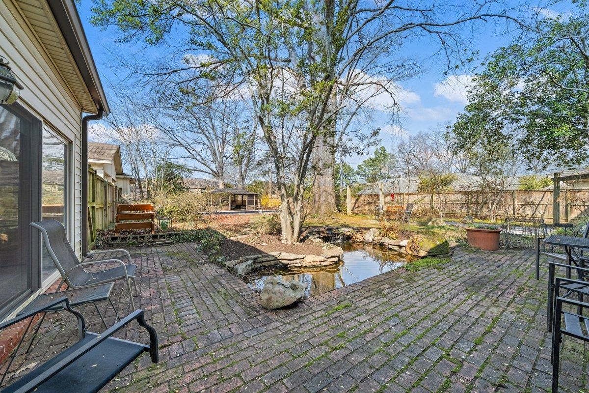353 Colonial Road Memphis, TN 38117 - Photo 34 of 37 Fenced backyard with a small pond and a patio