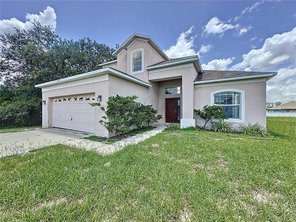 a front view of a house with a yard and garage