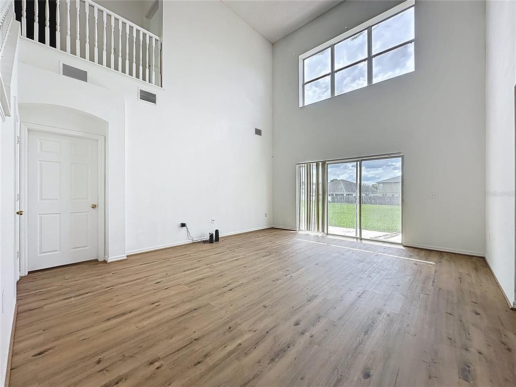 1430 Nelson Brook Way Kissimmee, FL 34759 - Photo 15 of 37 a view of an empty room with wooden floor and a window