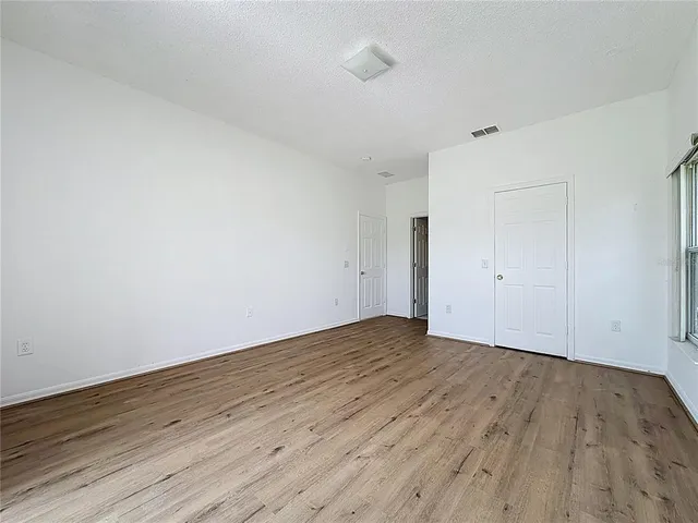 a view of an empty room with wooden floor