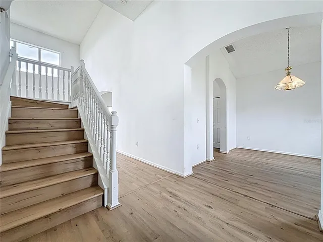a view of a hallway with wooden floor and staircase