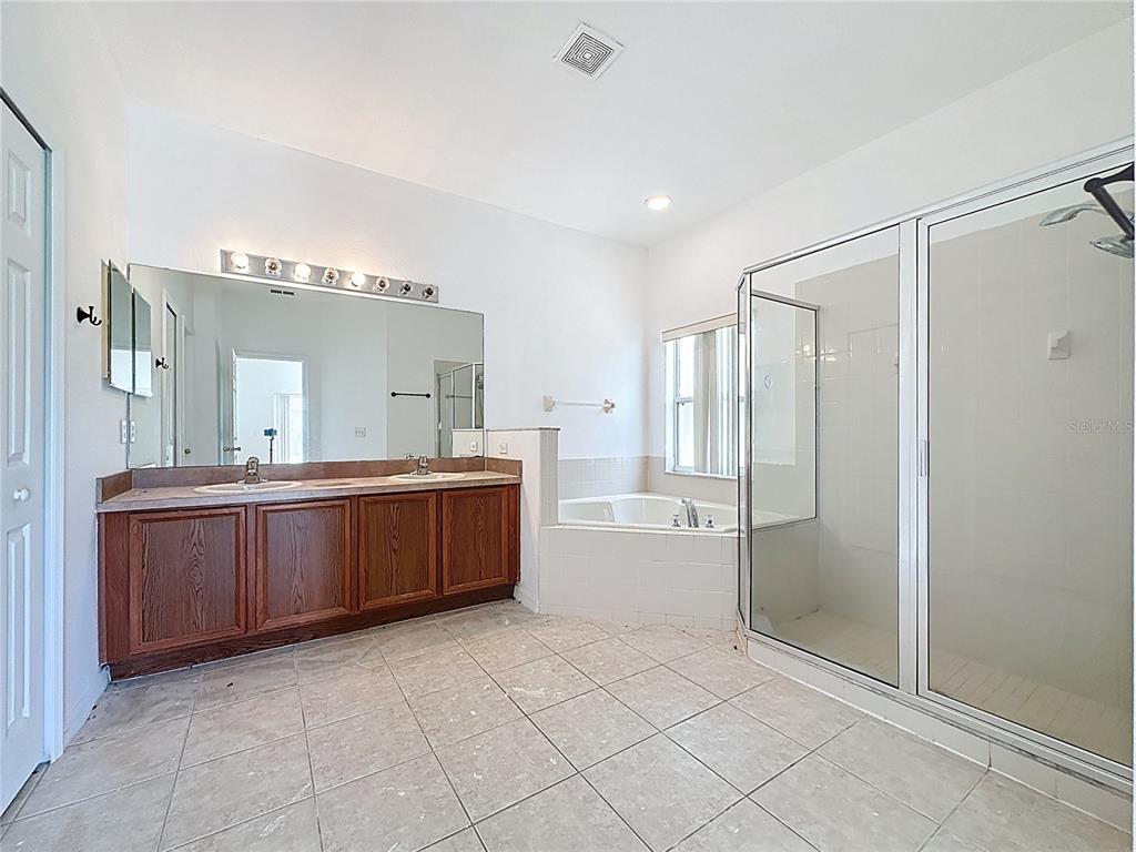 1430 Nelson Brook Way Kissimmee, FL 34759 - Photo 29 of 37 a large bathroom with a glass door shower a sink and mirror