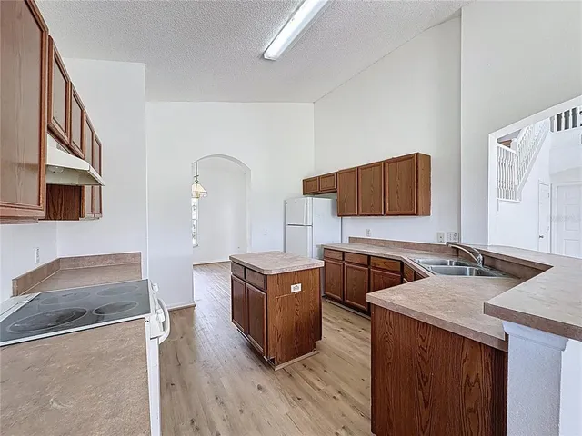 a kitchen with stainless steel appliances granite countertop a sink stove and wooden floor
