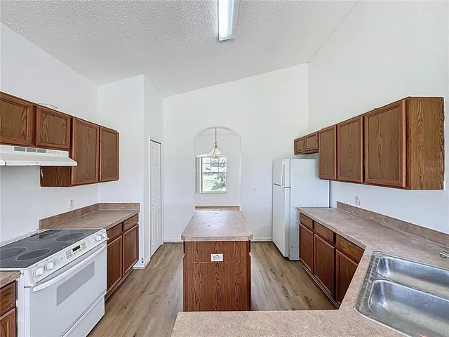 a kitchen with wooden cabinets and a stove top oven