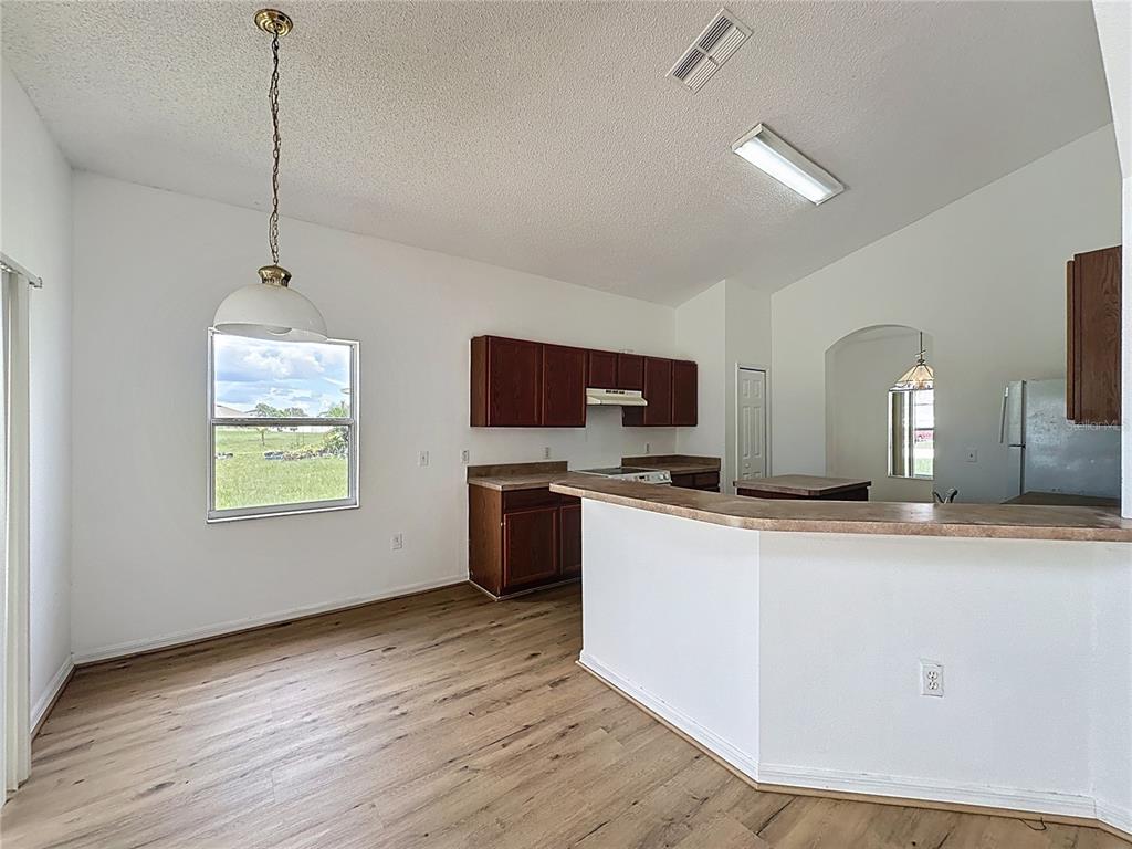 1430 Nelson Brook Way Kissimmee, FL 34759 - Photo 6 of 37 a kitchen with stainless steel appliances granite countertop a sink dishwasher a refrigerator and a stove with wooden floor