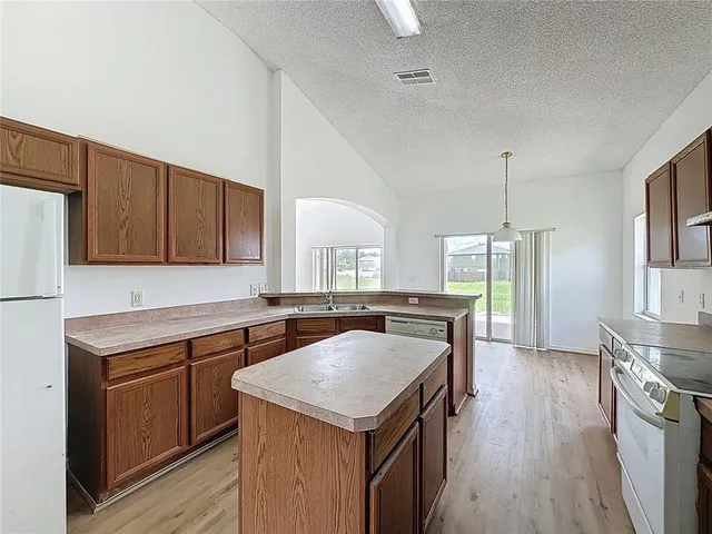a kitchen with a stove sink and cabinets