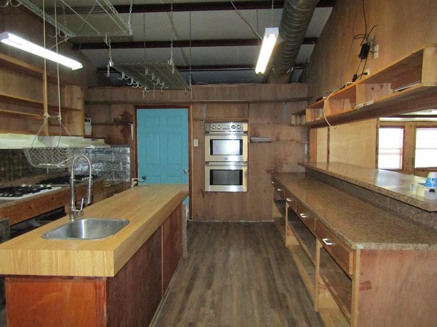 3178 East 2150 Road Grant, OK 74738 - Photo 27 of 40 a kitchen with stainless steel appliances granite countertop a sink a stove and a wooden floors