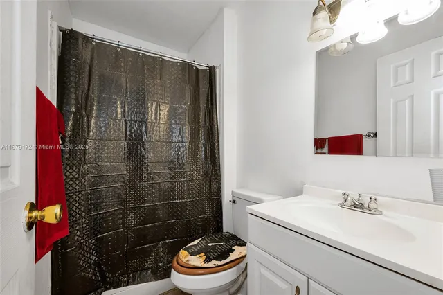 a bathroom with a sink toilet vanity and shower