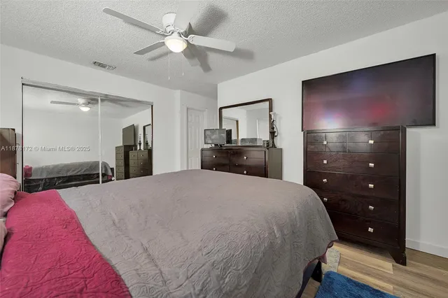 a spacious bedroom with a bed and a flat screen tv