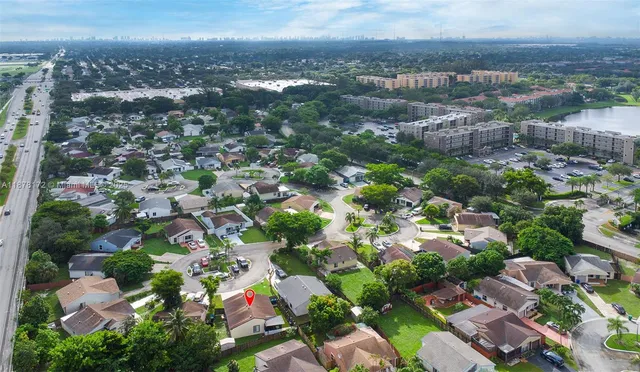 an aerial view of residential houses with outdoor space and trees