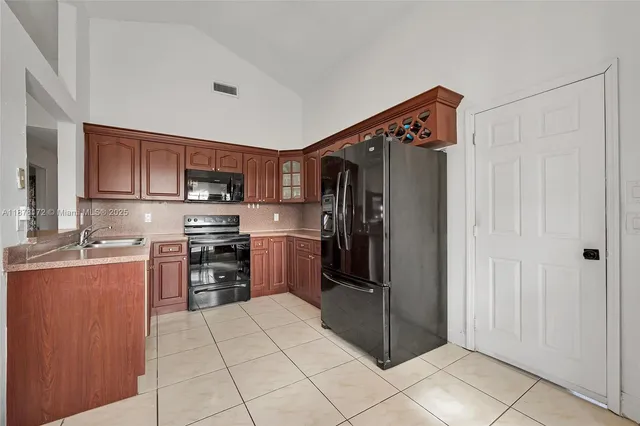 a kitchen with stainless steel appliances granite countertop a refrigerator and a stove top oven