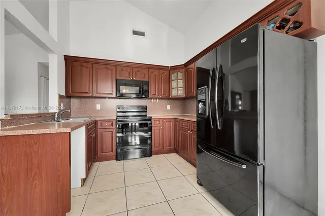 a kitchen with stainless steel appliances granite countertop a refrigerator and a stove top oven