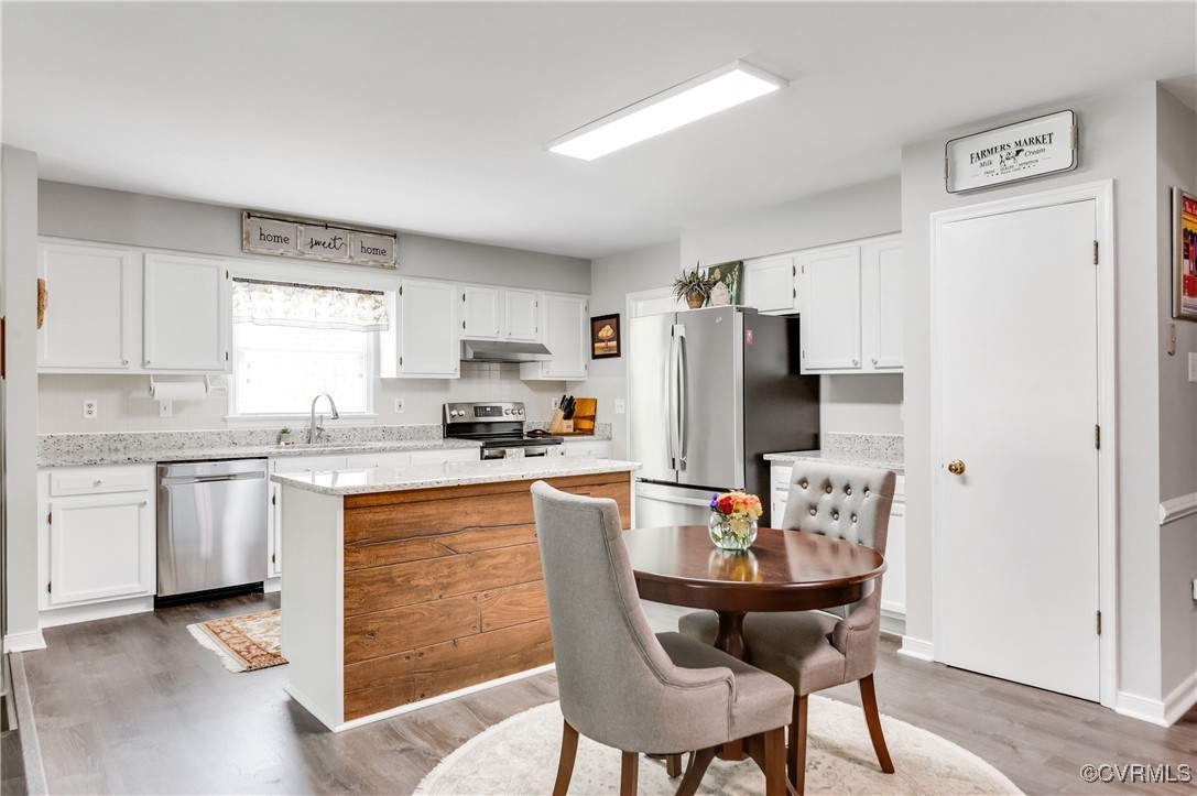 7111 Ledo Road Moseley, VA 23120 - Photo 12 of 47 a kitchen with stainless steel appliances kitchen island granite countertop a refrigerator a stove a sink dishwasher and white cabinets with wooden floor