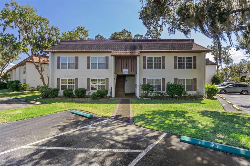a front view of a house with a yard and trees