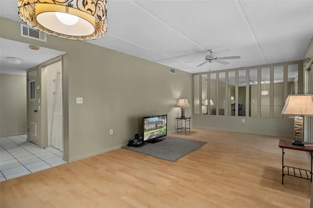 a spacious bedroom with a bed a table and a lamp