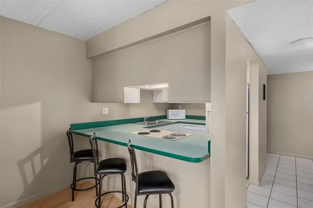 a kitchen with white cabinets stove and sink