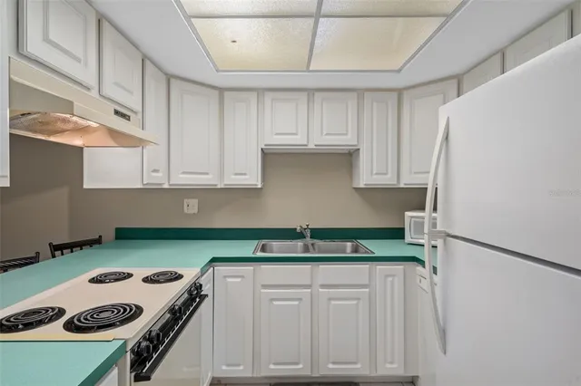 a kitchen with cabinets appliances and a sink