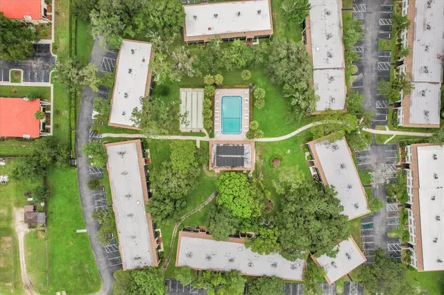 an aerial view of residential houses with outdoor space and trees