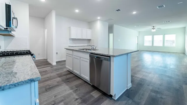 a kitchen with granite countertop a stove and a sink