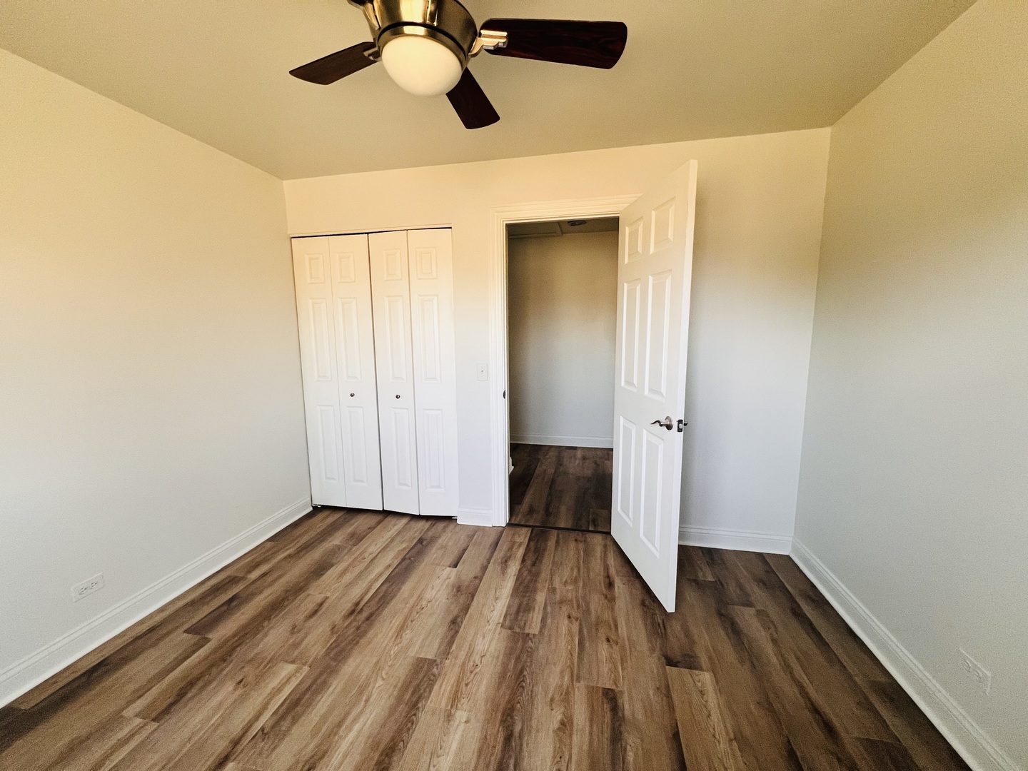 575 Greystone Lane, Unit A2 Wheeling, IL 60090 - Photo 13 of 13 a view of a room with wooden floor closet ceiling fan and window