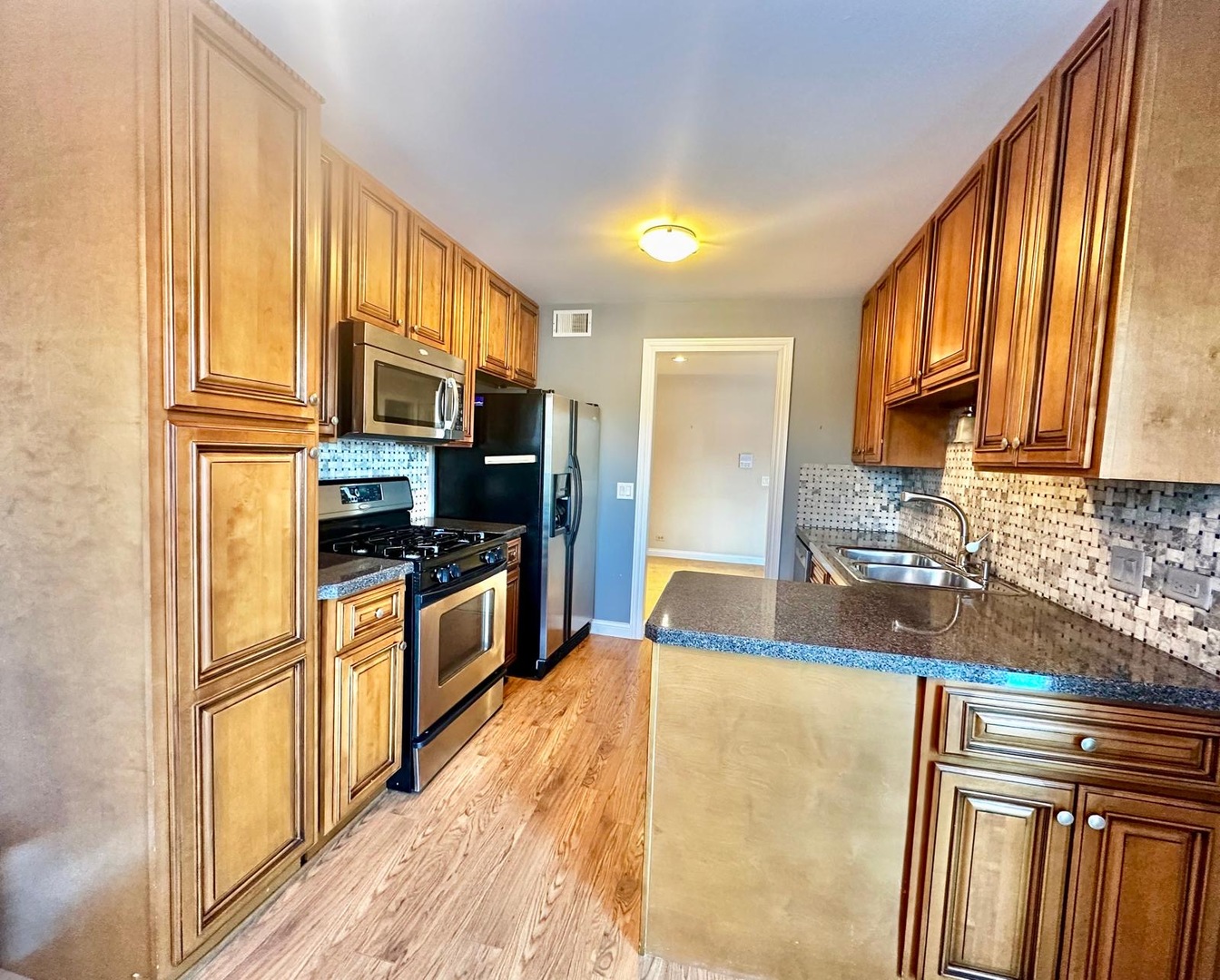 575 Greystone Lane, Unit A2 Wheeling, IL 60090 - Photo 6 of 13 a kitchen with stainless steel appliances granite countertop a refrigerator a stove top oven a sink and dishwasher