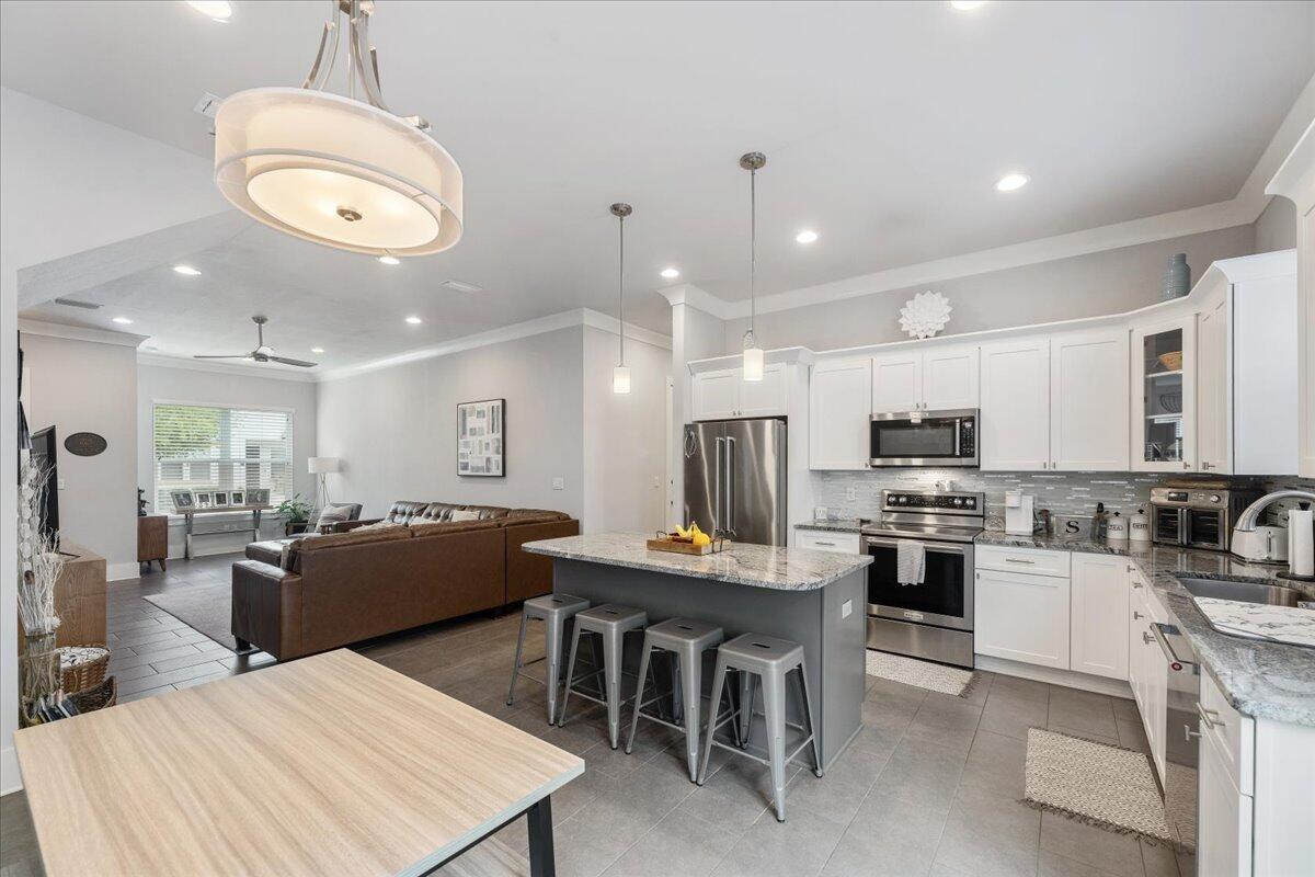995 Airport Road, Unit 26 Destin, FL 32541 - Photo 1 of 39 a large kitchen with kitchen island a sink table and chairs